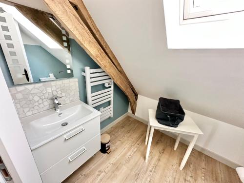 a bathroom with a sink and a table and a mirror at Maison - 2 chambres - Terrasse - Babyfoot in Verton