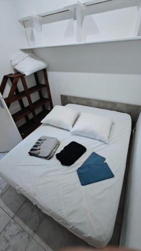 - un lit avec des draps blancs et des oreillers bleus dans l'établissement pavillon 40m2, 2 Chambres, 1 salon cuisine, 1sdb, à Gruissan