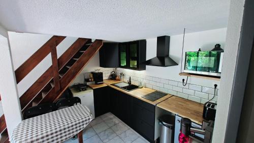 - une petite cuisine avec des placards noirs et un évier dans l'établissement pavillon 40m2, 2 Chambres, 1 salon cuisine, 1sdb, à Gruissan