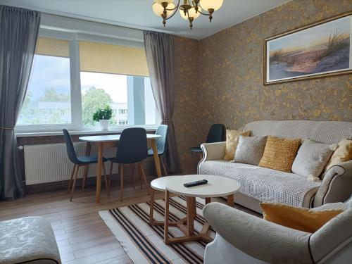 a living room with a couch and a table at Apartamentai Šviesa 2 in Palanga