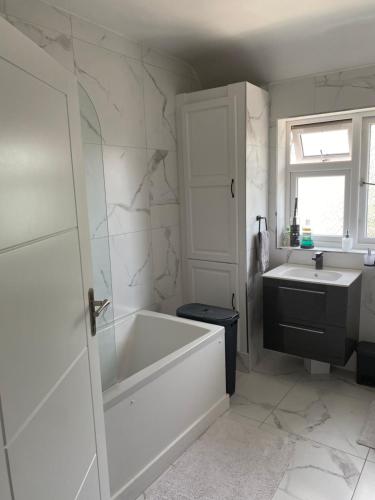 a white bathroom with a tub and a sink at 35 Holborn road London E13 8PH Near EXCEL EXHIBITION CENTRE in London