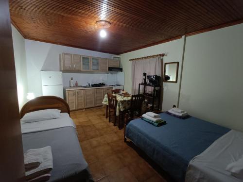 a small room with two beds and a kitchen at LittleParadise100MFromTheBeach in Áyioi Apóstoloi