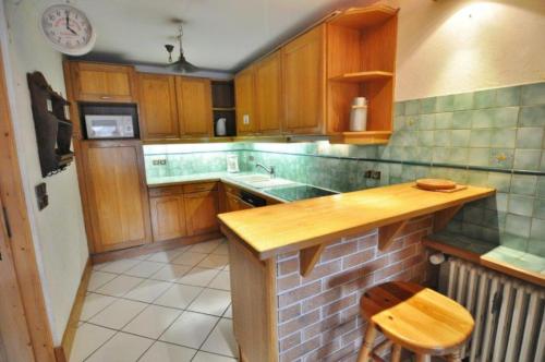 une cuisine avec des armoires en bois et un comptoir dans l'établissement Les Dents du midi-Echo de la corne, à La Chapelle-dʼAbondance