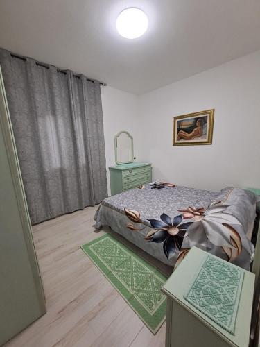 Un dormitorio con una cama y una cómoda y una ventana. en Maristella, en Olbia