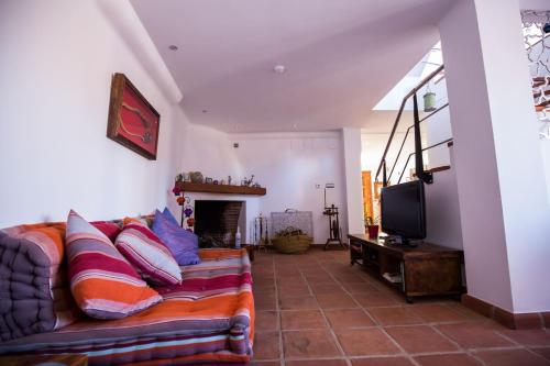 salon z kanapą i telewizorem w obiekcie Casa Alegria w mieście Lentegí