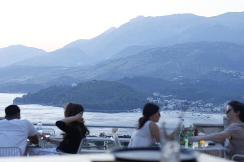 um grupo de pessoas sentadas à mesa com vista para a água em Sunset Serenity em Himare