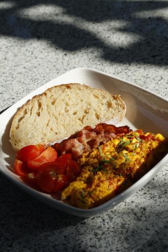 um prato de comida com uma fatia de pão e tomates em Sunset Serenity em Himare