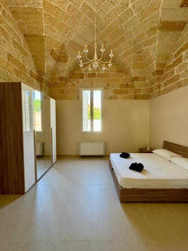 1 dormitorio con 1 cama grande y techo de piedra en Casa Zia Anna, en Torchiarolo