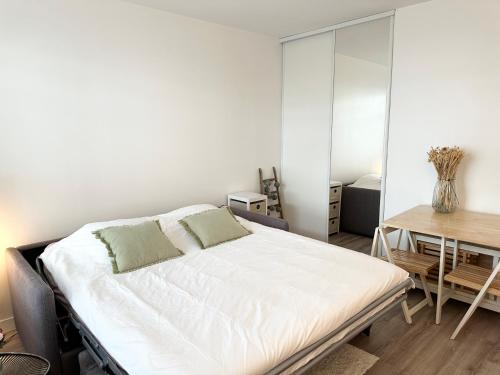 une chambre blanche avec un lit et un bureau dans l'établissement Appartment 5 min from Paris - parking included, à Levallois-Perret
