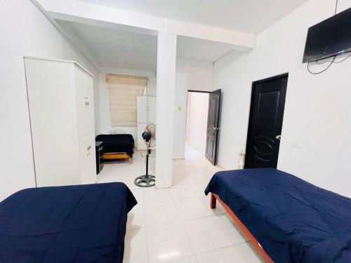 a bedroom with two beds and a television in it at sol de oro in Talara