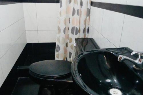 a bathroom with a black toilet and a sink at Independiente Minidepa Yanahuara in Yanahuara