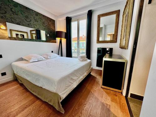 une chambre avec un lit et une grande fenêtre dans l'établissement ApartHotel Riviera - LE PETIT BALCON DE L'OPERA - Old Town Promenade des Anglais, à Nice