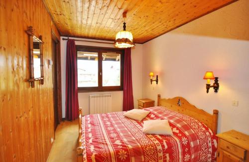 une chambre avec un lit avec une couverture rouge dans l'établissement Le Morclan, à La Chapelle-dʼAbondance