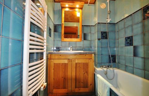 une salle de bain avec un lavabo, une baignoire et un miroir dans l'établissement Le Morclan, à La Chapelle-dʼAbondance