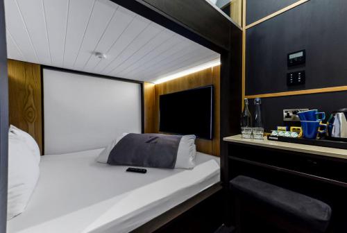 a small bedroom with a bed and a sink at The Z Hotel Holborn in London