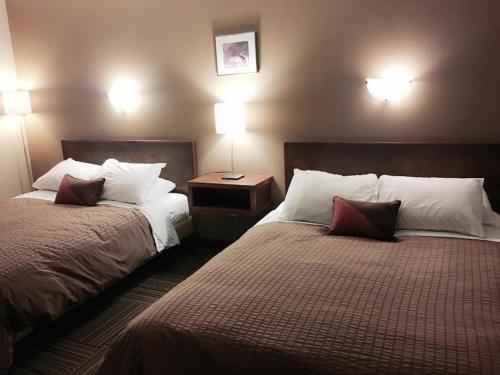 a hotel room with two beds and two lamps at Canterbury Inn in Invermere