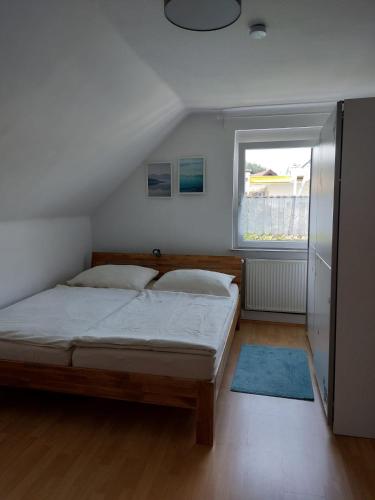 a bedroom with a bed and a window at Waldapartment in Kranzlhofen