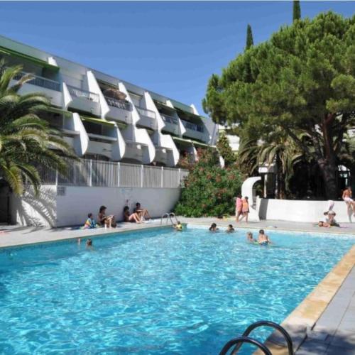 un groupe de personnes assises dans une piscine dans l'établissement Charmant studio Climatisé avec Terrasse, Piscine et Parking dans le beau quartier du PONANT, à La Grande Motte