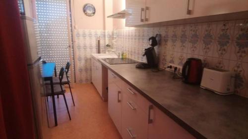 une cuisine avec des armoires blanches et un comptoir dans l'établissement Le Théthys C, à Six-Fours-les-Plages