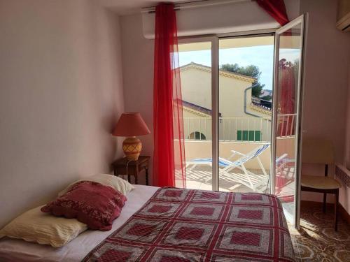 une chambre avec un lit et une vue sur un balcon dans l'établissement Le Théthys C, à Six-Fours-les-Plages