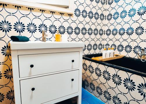 a bathroom with a white dresser and a patterned wall at Vetus pontem in Vrboska