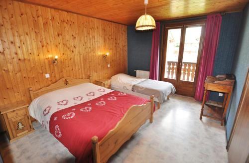 - une chambre avec 2 lits dans une pièce dotée de murs en bois dans l'établissement Le Mont Chauffé, à La Chapelle-dʼAbondance