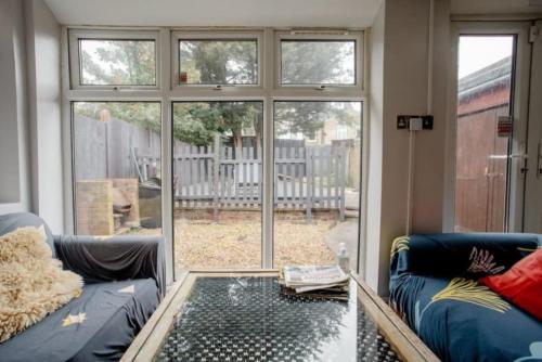 a living room with a couch and a large window at London Comfy Doubles in London