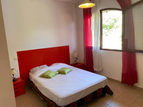 a bedroom with a bed with a red headboard and a window at GRANDE VILLA TIZZANO A 200 M DE LA PLAGE 18 PERS in Sartène