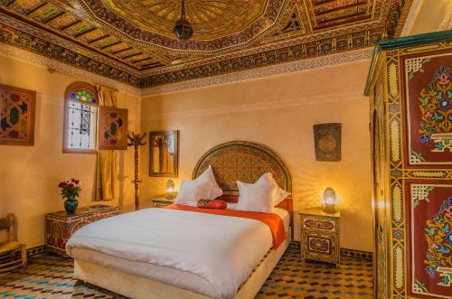 een slaapkamer met een groot bed en een plafond bij Riad Sidi Fatah in Rabat