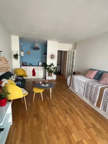 - une chambre et un salon avec un lit et une table dans l'établissement Studio cosy 15 mins de Paris centre, à Asnières-sur-Seine
