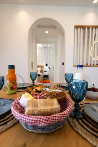 a table topped with a basket of bread and cheese at Gallantry apartment in Galanado