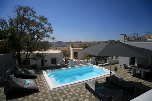 a swimming pool with chairs and an umbrella at Casa Di Soho Syros in Ermoupoli