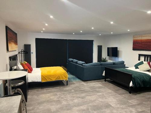 a bedroom with a bed and a couch and a table at The Pod in Crowhurst