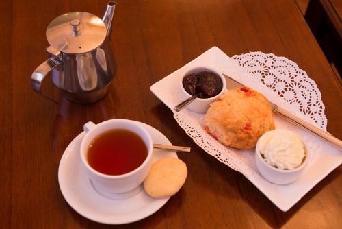 a table with a cup of tea and a plate of food at Kilmorey Arms Hotel in Kilkeel