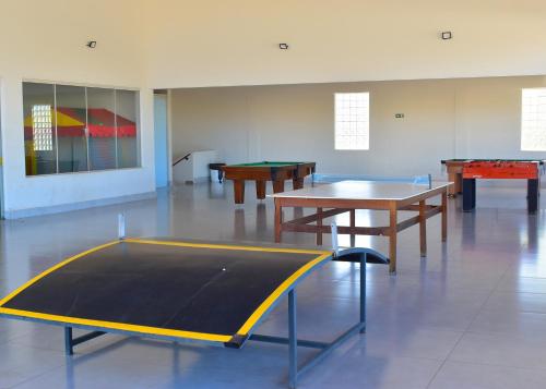 a room with two tables and a ping pong table at Nobreza Fiori Turismo em Caldas Novas Diroma Fiori SEM ROUPAS DE CAMA BANHO E REFEIÇÕES A SEREM CONTRATADAS SEPARADAMENTE DA RESERVA in Caldas Novas