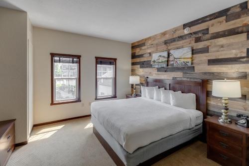 a bedroom with a bed and a wooden wall at Chase On The Lake in Walker