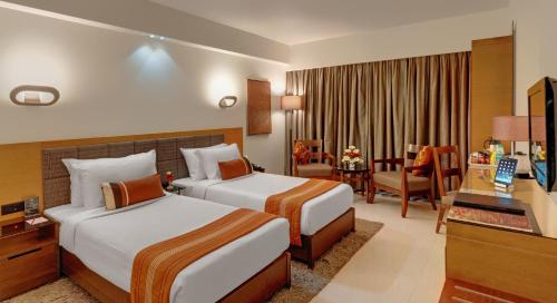 
a hotel room with two beds and two lamps at Hotel Suba International in Mumbai
