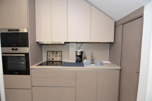 a kitchen with white cabinets and a sink at Chic Living 3 in Kavala