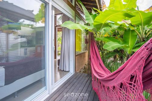 a hammock on the front porch of a house at VGZ - Cabanas charmosas entre Barra de Ibiraquera e Rosa in Imbituba