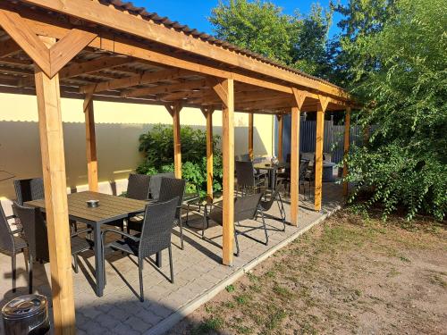 a wooden pergola with a table and chairs on a patio at Belvárosi Lux Apartman 2 in Vásárosnamény