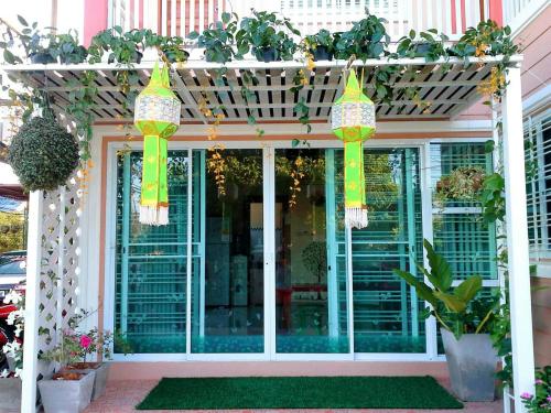a front porch with a pergola with plants at Lampang Lanna Home in Lampang