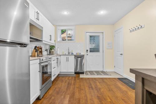 ロンドンにあるElegant & Private Apartment - Short Walk From Downtownの白いキャビネットと木製の床を備えたキッチン