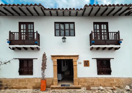 a white house with two balconies and a door at Hotel Verona Villa de Leyva in Villa de Leyva