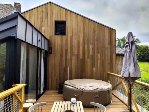 a hot tub on the deck of a house at Marie à la Campagne in Dolembreux