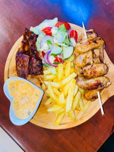 a plate of food with meat french fries and a salad at Nteto guesthouse in Dwarsloop