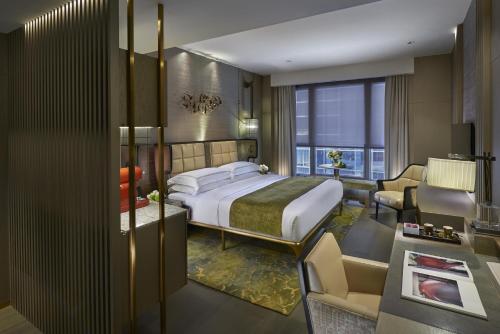 a bedroom with a bed and a living room at The Landmark Mandarin Oriental, Hong Kong in Hong Kong