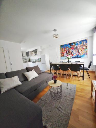 un salon avec un canapé gris et une table dans l'établissement Esbly Merveilleux Disney Home 6 à 8 pers, à Esbly