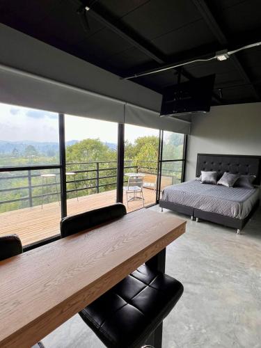 a bedroom with a bed and a wooden table at Eco Lodge Glamping in Guatapé