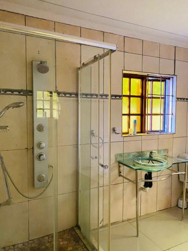 a bathroom with a glass shower and a sink at Nteto guesthouse in Dwarsloop