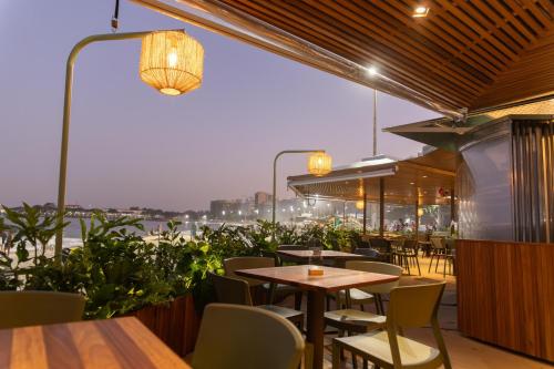 a restaurant with tables and chairs and a view of the water at Rio Othon Palace in Rio de Janeiro